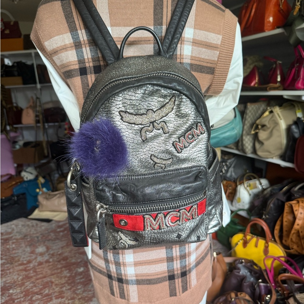 MCM Silver Backpack with Purple Pom Pom and Red Accents